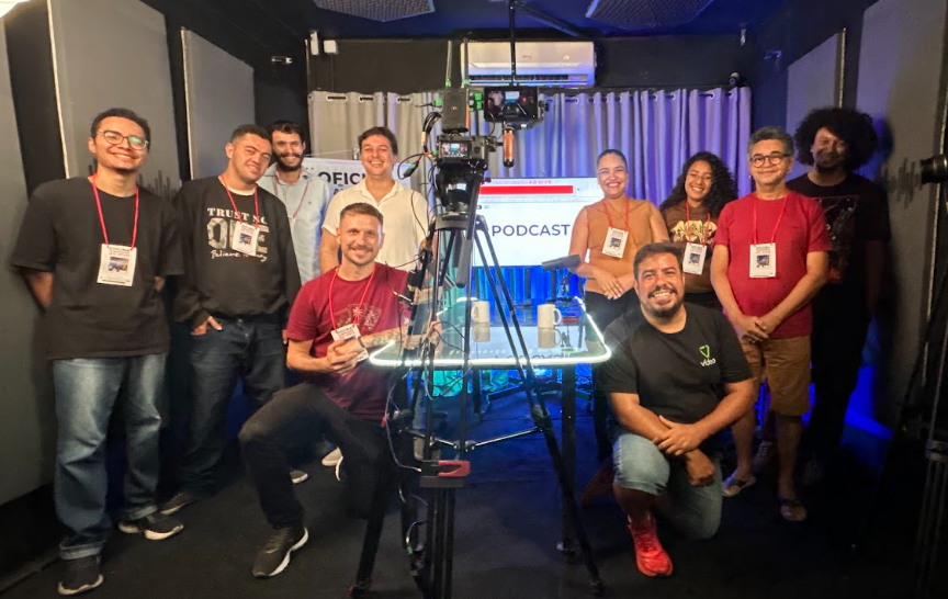Estúdio montado para uma transmissão ao vivo, com microfone, mesa de som e computador